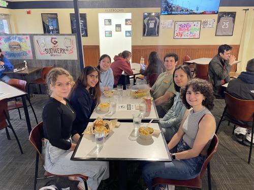 Five students having lunch with Dr. Jie Zheng