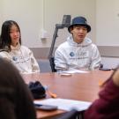 Two people sit on the opposite end of a table